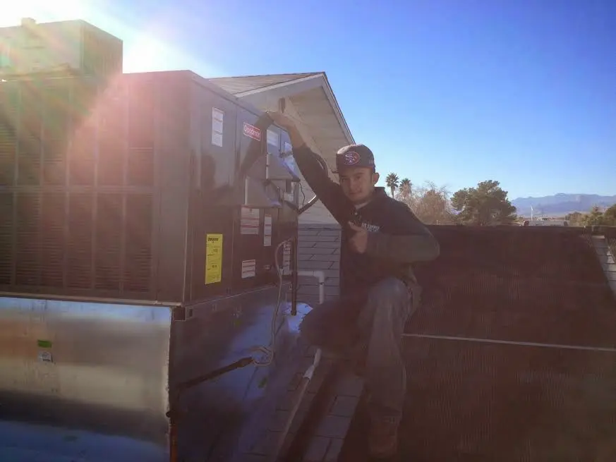 HVAC technician performing Air Duct Cleaning on a rooftop unit in North Charleston
